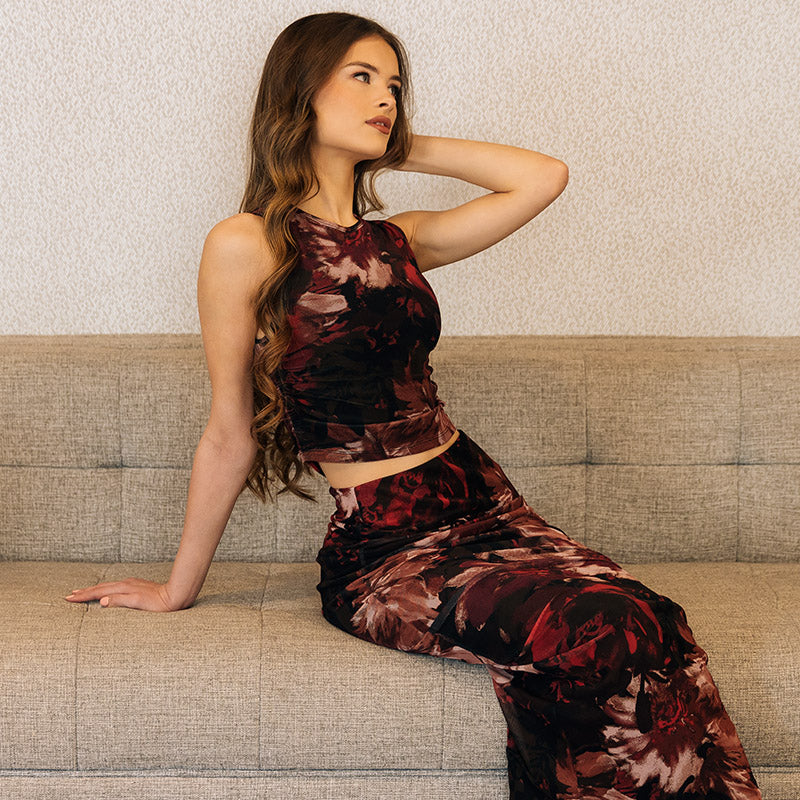 Model sitting on couch wearing the Floral Mesh High Neck Tank with matching skirt.