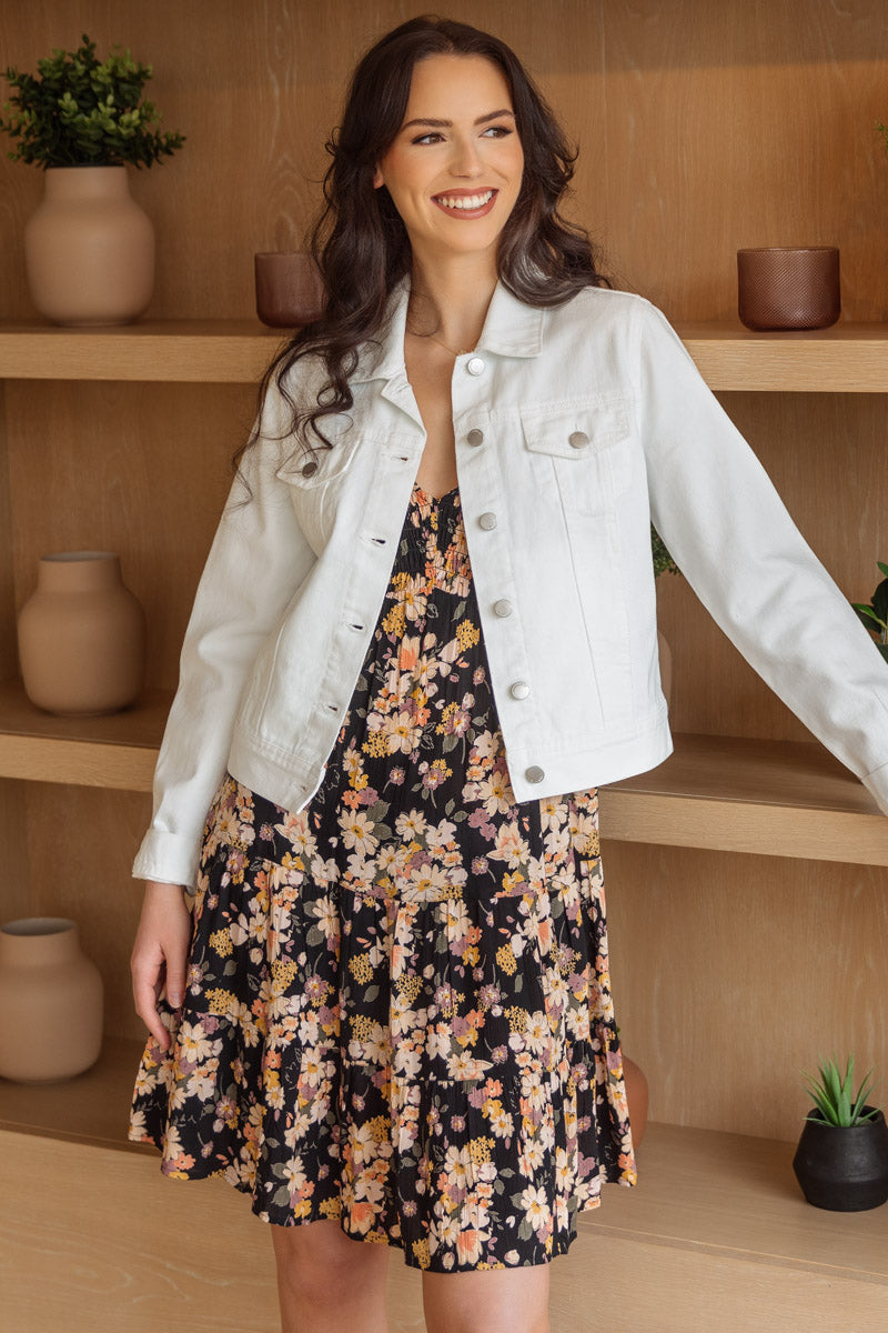 Model wearing a boho-inspired floral dress with a white jean jacket.